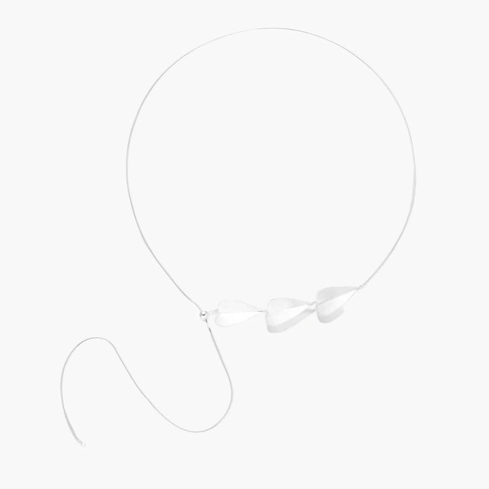 Minimalist sterling silver necklace with three brushed leaf-shaped pendants on delicate chain against white background