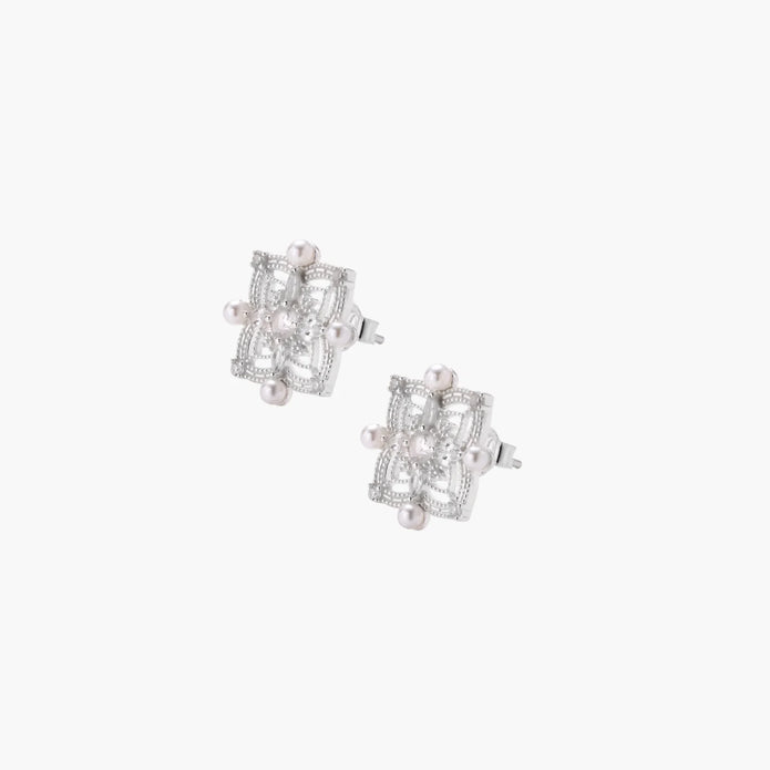 Ornate sterling silver stud earrings with mandala-inspired filigree pattern and four freshwater pearls on beige background