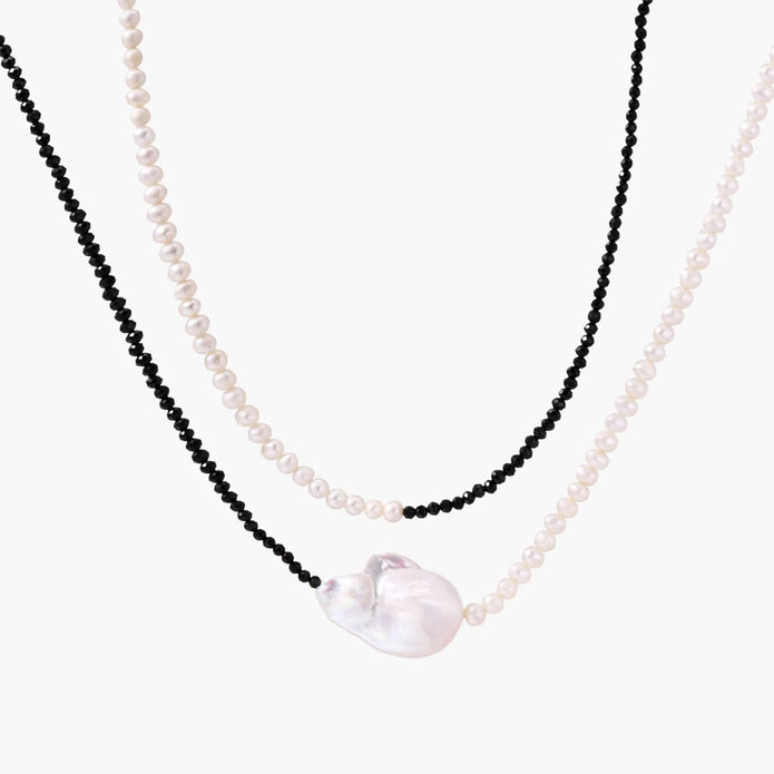 Double-strand necklace with black faceted quartz and white pearls featuring an oversized baroque pearl centerpiece