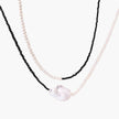 Double-strand necklace with black faceted quartz and white pearls featuring an oversized baroque pearl centerpiece