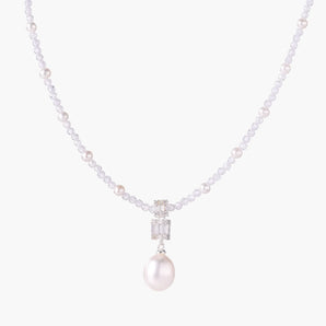 Dainty necklace with lavender crystal beads, freshwater pearls, geometric pendant, and large pearl drop on white background.