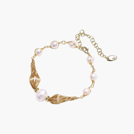 Adjustable gold bracelet with freshwater pearls and textured filigree beads on white background, showing clasp detail.