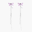 Long drop earrings with translucent lavender enamel dragonfly wings and white gold plated segmented bodies on white background