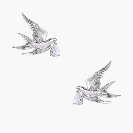Silver-toned swallow stud earrings with detailed wings carrying teardrop zirconia crystals on white background