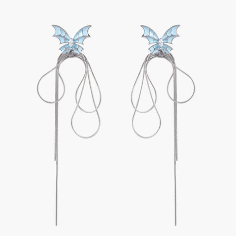 Long silver-tone earrings with powder blue enamel butterfly studs and flowing chain tassels on cream background