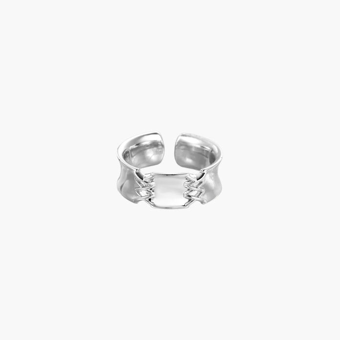 Adjustable silver-toned ring with sculptural stitch design across polished white gold-plated brass band