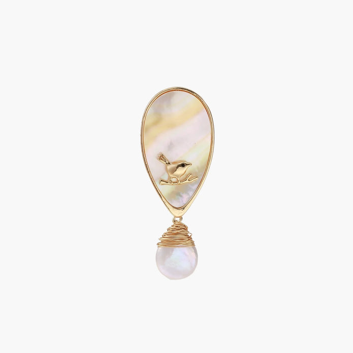 Iridescent shell brooch with gold bird accent and wire-wrapped baroque pearl drop on cream background.