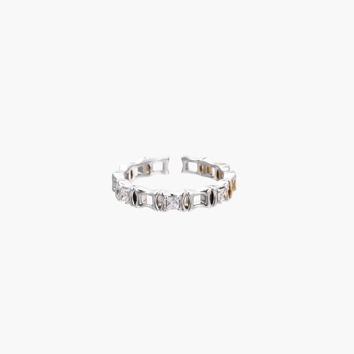 White gold plated ring with architectural lattice design and zirconia accents on cream background