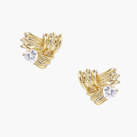 Pair of sculptural gold-plated wing stud earrings with zirconia stones on cream background, showing dimensional feather design