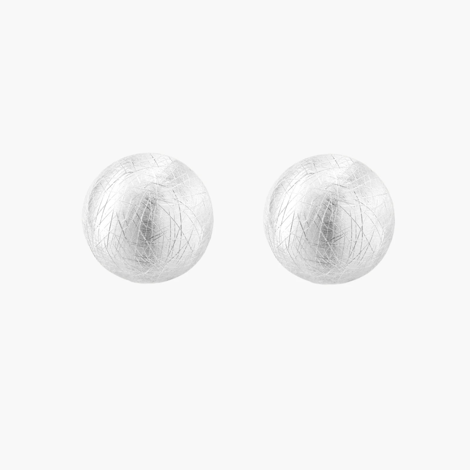 Brushed sterling silver half-dome clip-on earrings with textured surface against cream background