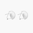 Brushed sterling silver half-dome clip-on earrings with textured surface against cream background