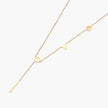 Gold Y-shaped necklace with L-O-V-E letter charms and vertical bar pendant on delicate chain against cream background