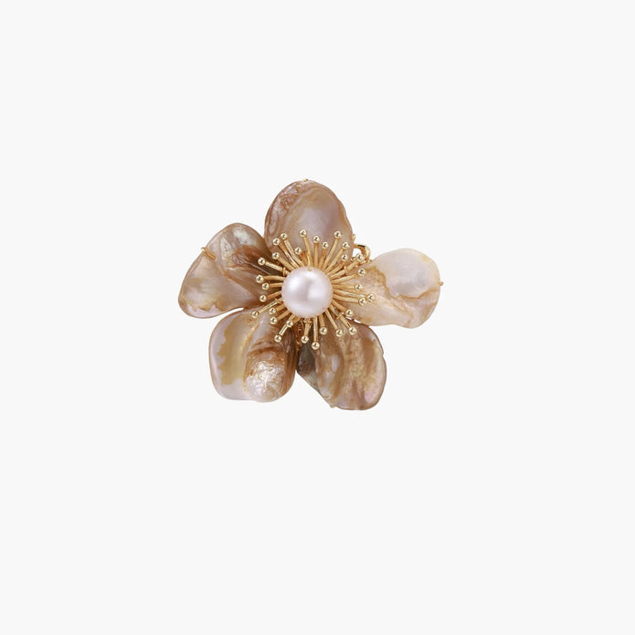 Flower-shaped brooch with iridescent shell petals, freshwater pearl center, and gold-plated radiating details.