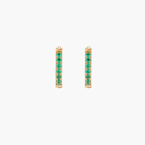 Pair of small gold huggie hoop earrings with bright green cubic zirconia stones on cream background