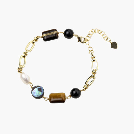 Gold chain bracelet with tiger's eye, obsidian, pearl, and iridescent abalone stones on cream background.