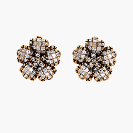 Gold-plated floral stud earrings with geometric zirconia crystals arranged in five-petal design on cream background