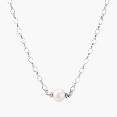 Dainty rhodium-plated silver chain necklace with centered 10mm freshwater pearl and crystal accents on cream background