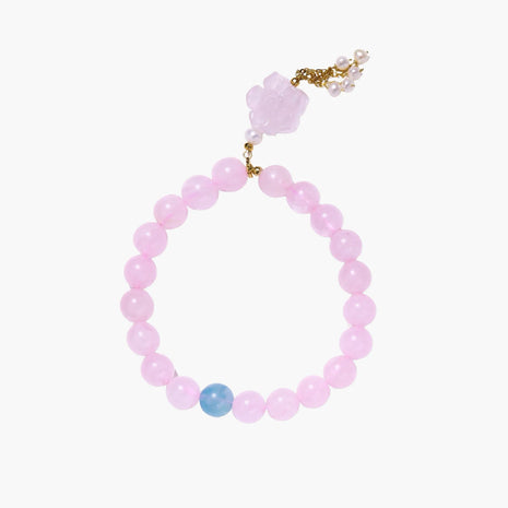 Stretchy beaded bracelet with pink rose quartz, blue aquamarine, carved floral pendant, and pearl tassel clasp.