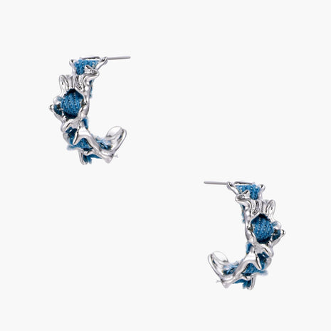White gold plated hoop earrings with woven blue denim fabric through organic branch-like metal framework