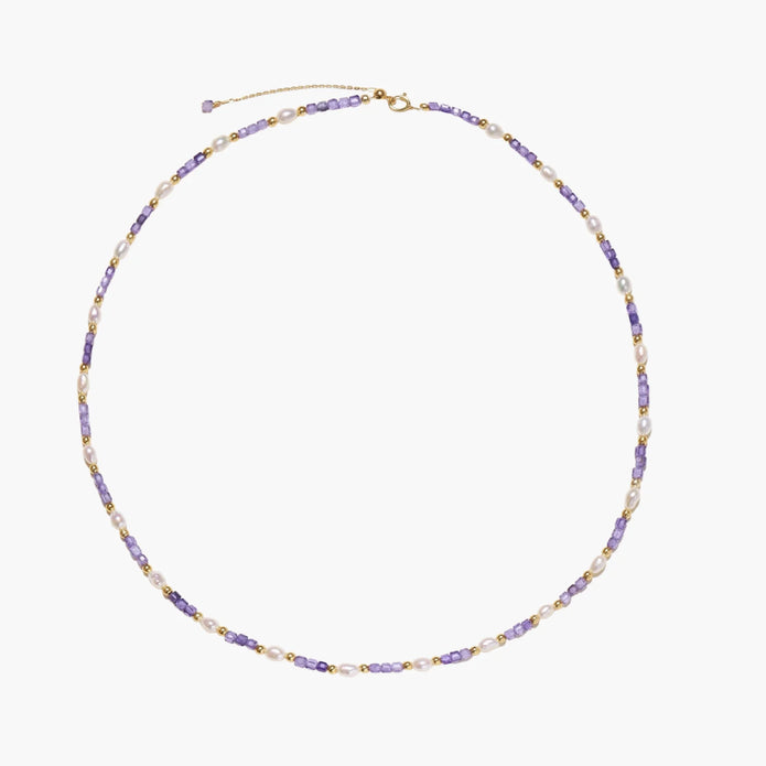 Delicate 18K gold vermeil necklace with alternating lavender zirconia beads and white freshwater pearls on cream background