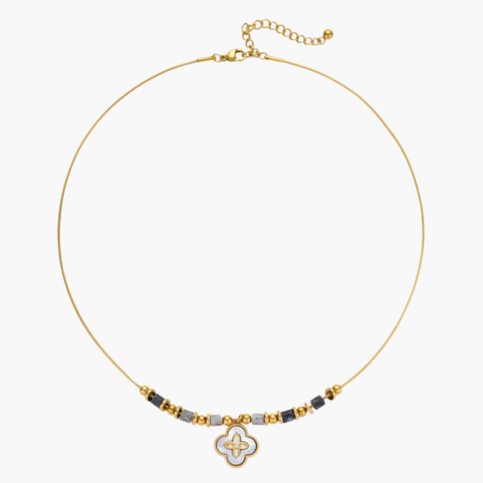 Gold-toned beaded necklace with grey stones and quatrefoil abalone shell pendant on cream background.