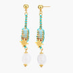 Gold-plated dangle earrings with turquoise threading, star charms, and white pearl beads against cream background.