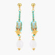 Gold-plated dangle earrings with turquoise threading, star charms, and white pearl beads against cream background.