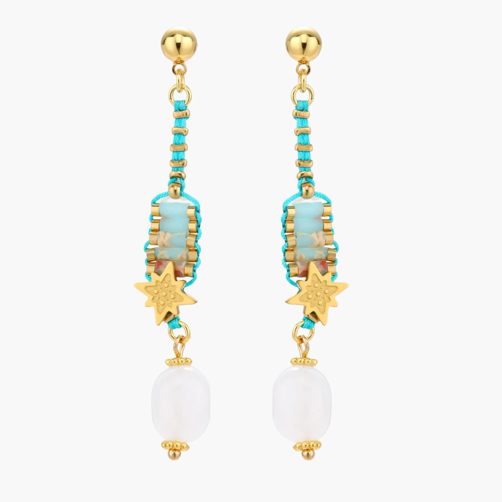 Gold-plated dangle earrings with turquoise threading, star charms, and white pearl beads against cream background.