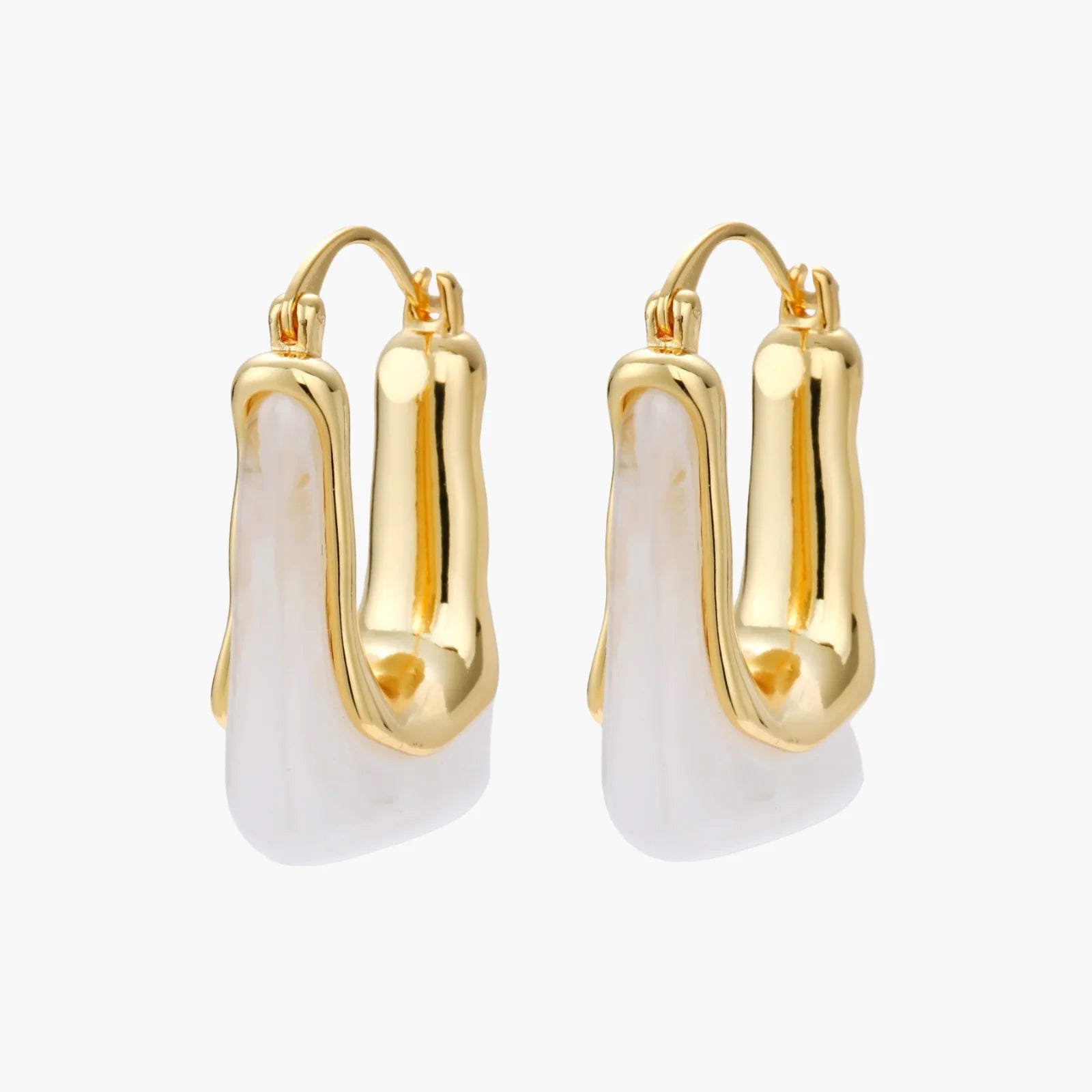 Sculptural gold-plated hoop earrings with flowing curved design and lever-back closure on cream background.
