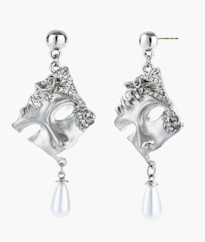 Ornate silver-toned theatrical mask earrings with crystal details and pearl drops on white background.