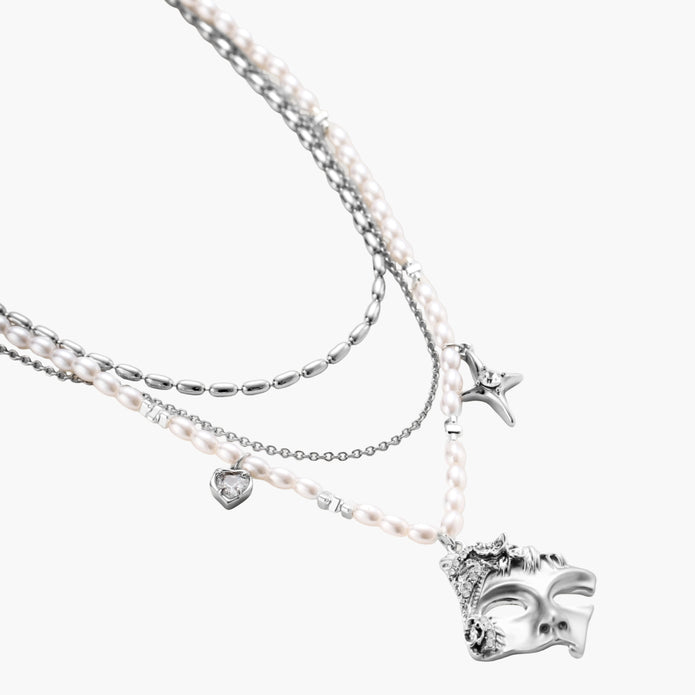 Multi-strand layered necklace set with silver chains, white pearls, star charm, heart pendant, and ornate decorative piece