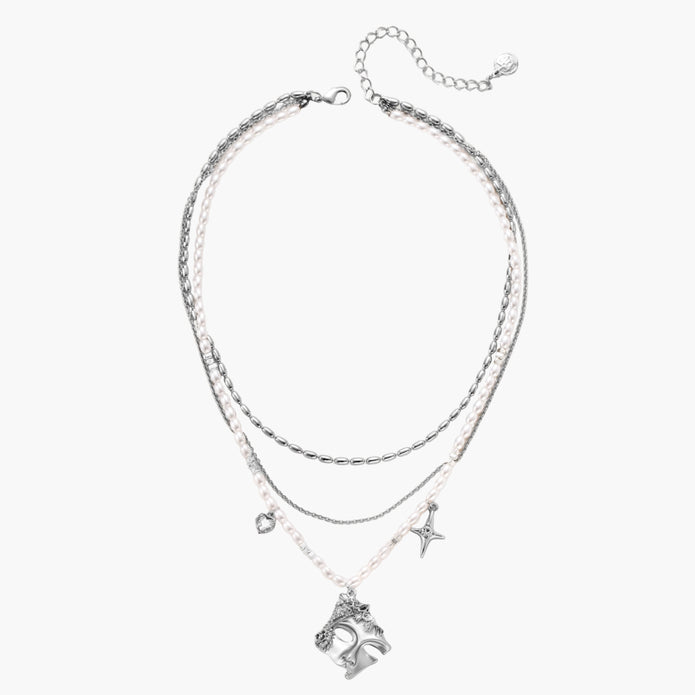 Multi-strand layered necklace set with silver chains, white pearls, star charm, heart pendant, and ornate decorative piece