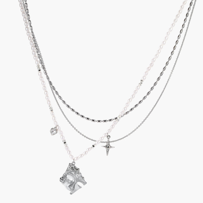 Multi-strand layered necklace set with silver chains, white pearls, star charm, heart pendant, and ornate decorative piece