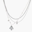 Multi-strand layered necklace set with silver chains, white pearls, star charm, heart pendant, and ornate decorative piece