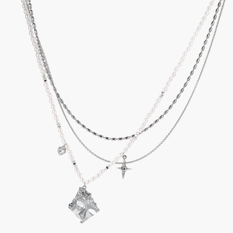 Multi-strand layered necklace set with silver chains, white pearls, star charm, heart pendant, and ornate decorative piece