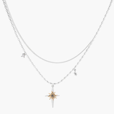 Two-layer silver-toned necklace with star charms and dagger pendant featuring golden sun motif on white background.