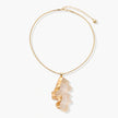 Close-up of a sculptural necklace with flowing wave pendant made from eco-zinc alloy on adjustable chain
