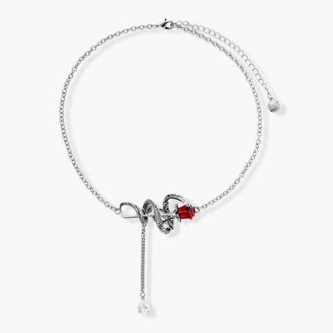 Detailed eco-brass serpent pendant necklace with red zirconia stone and crystal drop tassel on adjustable chain