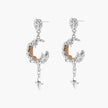 Detailed eco-brass dangle earrings featuring crescent moons with gold rope details and dangling star charms on white background.