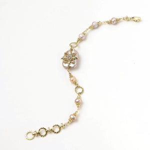 Gold-plated bracelet with pink baroque pearl centerpiece, floral connector, and freshwater pearls