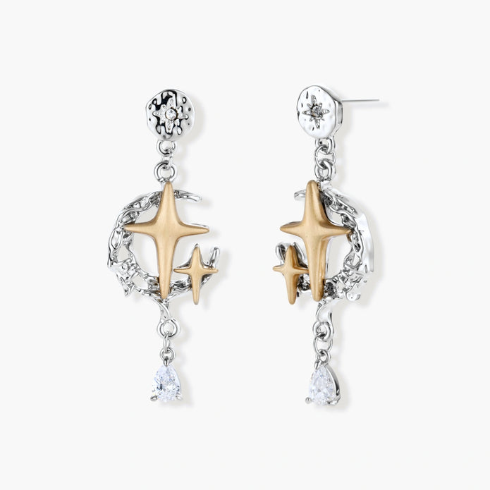 Two-tone star earrings with gold celestial motifs, silver chains, and clear crystal droplets on white background.
