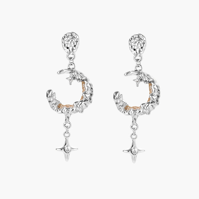 Detailed eco-brass dangle earrings featuring crescent moons with gold rope details and dangling star charms on white background.