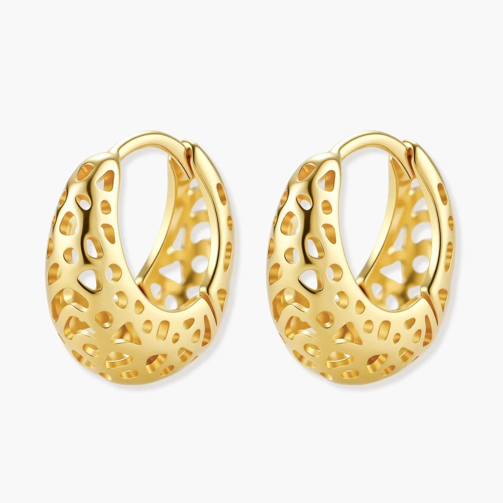 Close-up of small gold-plated hoop earrings with intricate honeycomb cutout pattern on cream background.