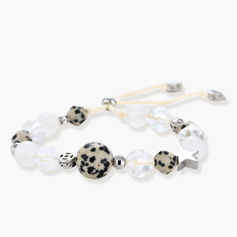 Adjustable beaded bracelet with spotted dalmatian stones, clear quartz crystals, and silver star charm on white background.
