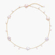 Gold vermeil chain with iridescent star-shaped baroque pearls and small round freshwater pearl drops on cream background.