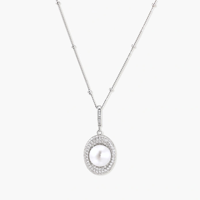 Oval sterling silver pendant with crystal halo surrounding a white freshwater pearl on delicate chain