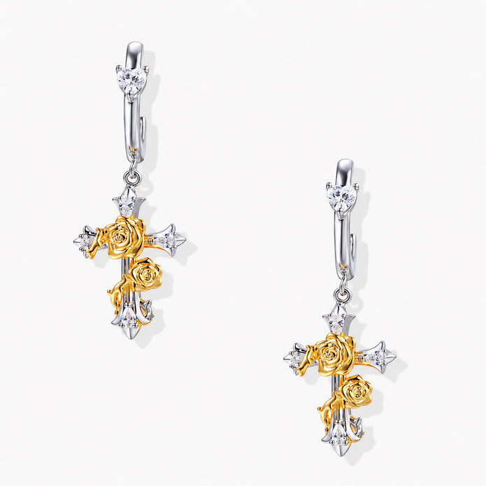 Two-tone silver and gold-plated cross drop earrings with rose motifs and zirconia stones on a huggie hoop base.
