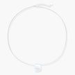 Minimalist brushed sterling silver dome pendant on delicate chain against cream background, showing matte textured finish