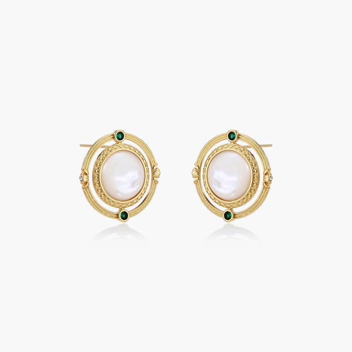 Circular gold stud earrings with iridescent mother-of-pearl center and green zirconia accents on cream background.
