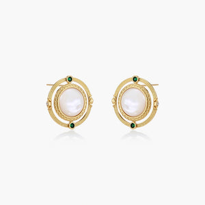 Circular gold stud earrings with iridescent mother-of-pearl center and green zirconia accents on cream background.